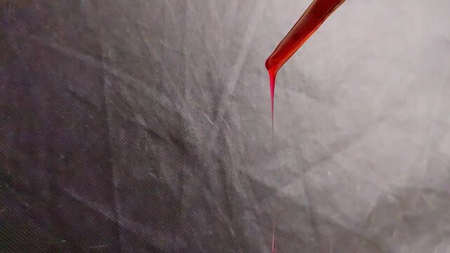 Red paint or dark blood dripping slowly for a spooky Halloween horror scene