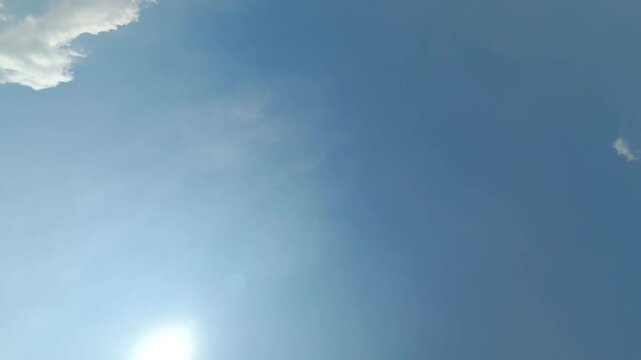 A dynamic high angle aerial acrobatics shot tracking an FPV drone as it executes a loop backflip stunt above a lush green agricultural soybean crop field in Milton Ontario on a sunny day.