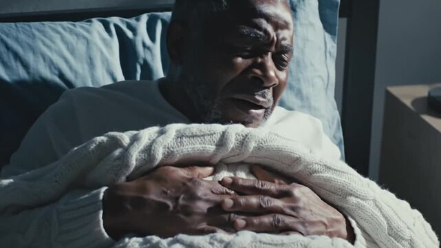 Elderly Man In Bed Experiencing Chest Discomfort And Pain
