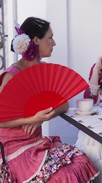 Spanish Flamenco Woman Portrait with a fan in Colorful Traditional Costume at a Charming Old Town Cafe