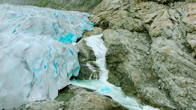 Aerial drone footage of the Nigardsbreen glacier, one of the glacier arms of the Jostedalsbreen ice cap in Norway. Various views show the blue-white glacier ice, crevasses, rocky surroundings and melt