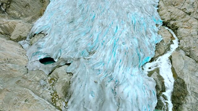 Aerial drone footage of the Nigardsbreen glacier, one of the glacier arms of the Jostedalsbreen ice cap in Norway. Various views show the blue-white glacier ice, crevasses, rocky surroundings and melt