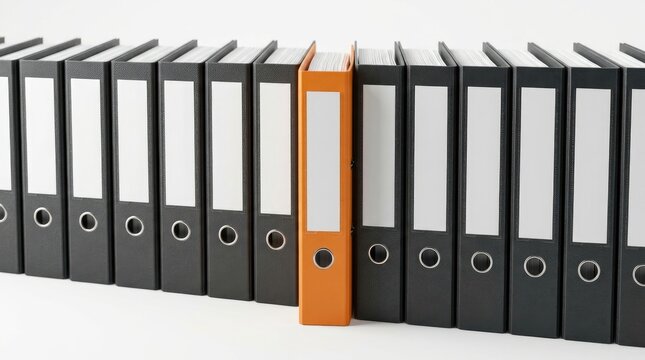 Row of black office ring binders standing on a white surface with one single orange binder in the middle representing standing out from the crowd