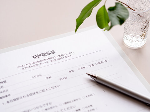 病院で記入する初診問診票とボールペンの写真