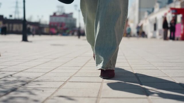 Walking calmly on sunny street. Quiet town road with relaxed movement and shadows. Peaceful stroll through sundappled small town street featuring vibrant clothing and soft shading patterns