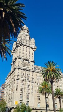 Vertical view of the iconic Palacio Salvo in Montevideo, Uruguay, under a clear blue sky. The historic landmark showcases Art Deco architecture, urban charm and the vibrant character of the city