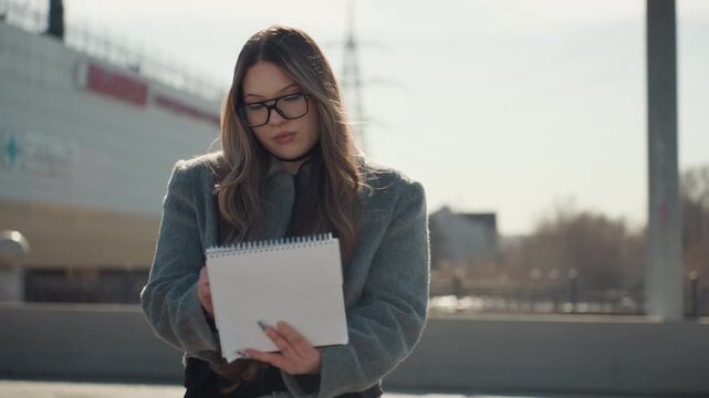 Female illustrator skillfully captures vibrant city views through detailed sketching. Woman passionately illustrates congested city landscapes using precise pencil and ink techniques