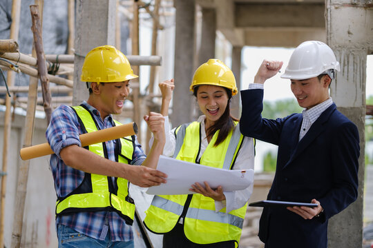 Architects, engineers and a manager discussing blueprints during a site inspection.