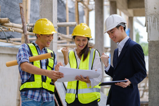Architects, engineers and a manager discussing blueprints during a site inspection.