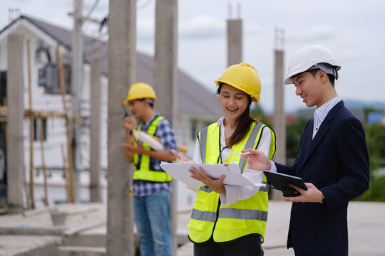 Architects, engineers and a manager discussing blueprints during a site inspection.