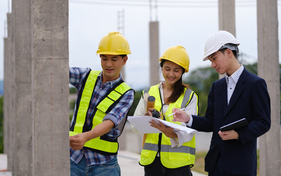 Architects, engineers and a manager discussing blueprints during a site inspection.