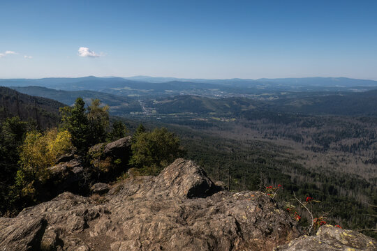 Wide mountain view from Kleiner Falkenstein across forests, valleys and distant hills of the Bavarian Forest in summer.