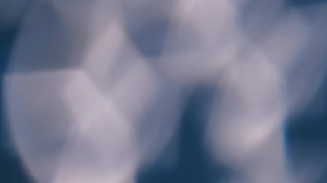 Defocused glare. Light background. Blur blue white color lens flare flicker leaking on illuminated creative optical art abstraction.