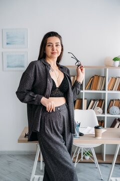 Professional workflow. Office worker. Happy relaxed business woman in modern atmosphere with coffee for preparing paperwork at desk.