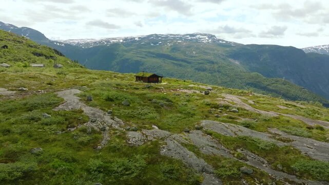 Aerial drone footage of mountain huts at M&aring;gelitopp, a high-altitude area and upper starting point of the Trolltunga hiking route in western Norway. Small traditional cabins are surrounded by open alp