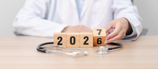 Fototapeta premium 2026 end year to Happy New Year 2027 with Stethoscope of doctor and heart shape on table. health care, Insurance, Wellness and medical concepts