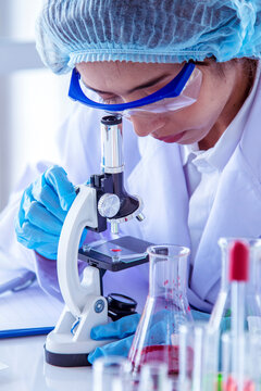 Vertical Horizon Woman scientist lab looks at science microscope medical test research biology chemistry. Scientist Chemistry Medical test lab. Vertical Females Technician Laboratory pharmacy research