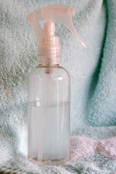 Clear spray bottle containing a colorless liquid with a pink trigger nozzle. Ideal for showcasing beauty. Cosmetic. And wellness products. Health. And cleanliness concepts