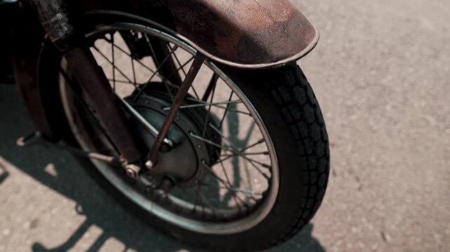 Close-up of a classic motorcycle tire at a standstill, showcasing the detailed tread pattern, rubber texture, and vintage character of the motorcycle wheel.
