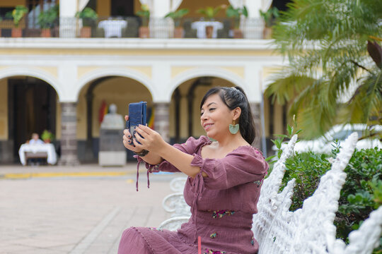 Cheerful Woman in Purple Dress Taking Selfie With Smartphone in Green Park