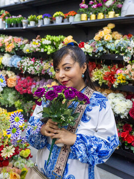 Happy Woman Holding Purple Artificial Roses in Colorful Flower Store