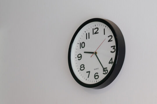 Wall clock with bold black numerals and red second hand