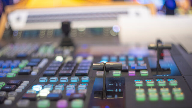 Video production switcher T-bar fader control panel with colorful buttons and copy space