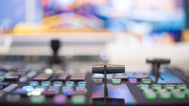 Professional broadcast switcher fader lever with colorful glowing buttons and copy space