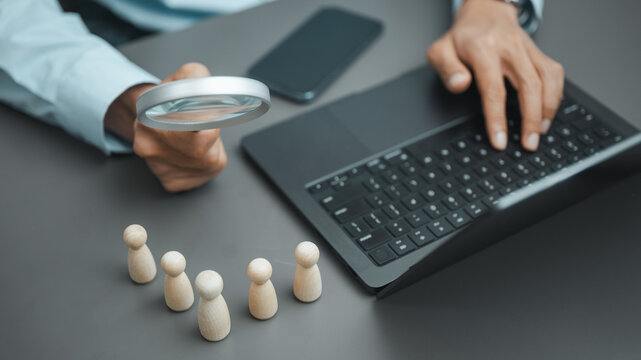 HR professional uses a magnifying glass to evaluate candidates for recruitment, hiring, and talent selection.
