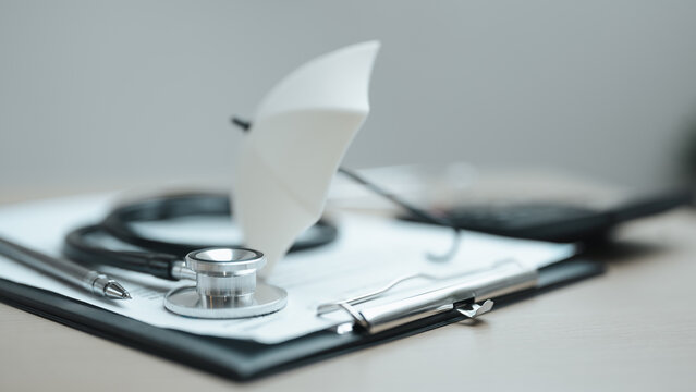 Medical insurance concept with stethoscope, clipboard, and umbrella illustrating healthcare coverage, financial protection, and patient benefits.