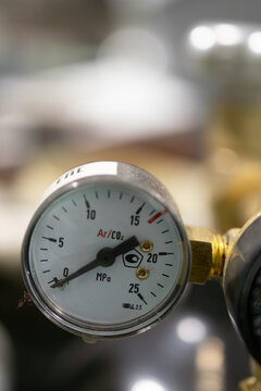 Close-up of pressure gauge and gas regulator in use in an industrial workshop