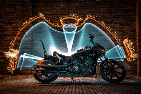 ein schweres Motorrad im Hintergrund ein Lichtbogen mit Feuer