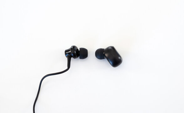 Auricular con cable y earbud inal&aacute;mbrico en comparaci&oacute;n sobre fondo blanco