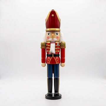 Nutcracker soldier stands as a traditional wooden figurine dressed in a vibrant red and blue military uniform against a clean white background.