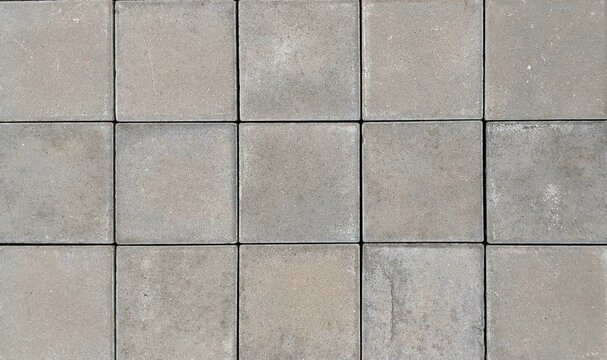 Top view close-up of grey square concrete paving slabs background texture, seamless outdoor stone floor tiles pattern for architectural design.