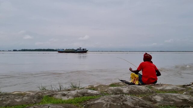 Fisherman casting fishing rod into wide river with boats water line man leisure recreation