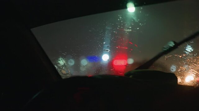 Drops slide down glass during peaceful journey. Tears of rain cascade over windshields during calm night ride. Soft raindrops shimmer on glass as cars glide through tranquil city landscape