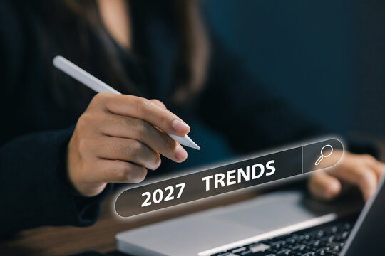 Businesswoman uses digital stylus with laptop and virtual search bar showing 2027 trends, representing future technology, market research, innovation, planning, and business forecast.