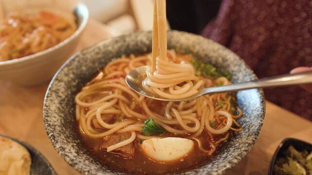 Close Up of Burmese Mee Shay Beef Noodle Soup with Chopsticks