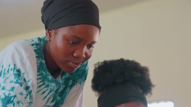 Mother guides child learning. Gentle environment showcasing mother aiding child with focus. Quiet indoor space where caring mother facilitates focused educational activity for child