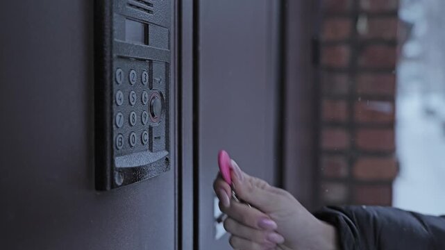 Woman Unlocking Apartment Entrance With RFID Key Fob, Winter Close Up Access