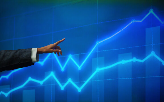 Business professional pointing at a digital stock market chart with rising index trends, presenting investment performance, financial analysis, trading data, and market growth insights.