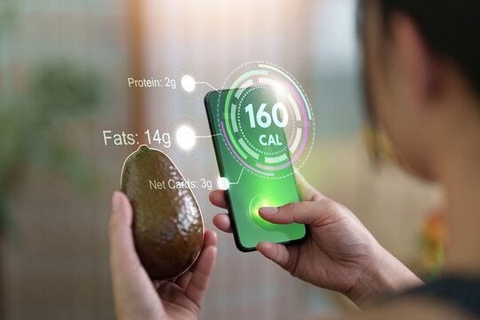 Person scanning fresh avocado with smartphone nutrition tracking app for calorie counter concept