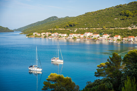 Panoramic view of Polace village on Mljet Island Croatia overlooking the Adriatic Sea. Peaceful Mediterranean coastal destination with anchored sailboats.
