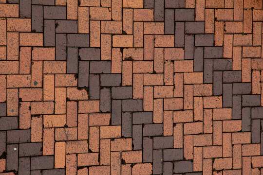 Pattern of bricks on the ground in a public area showing various shades and textures