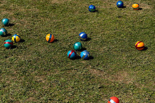 Colorful plastic balls on grass during an outdoor game event in bright sunlight