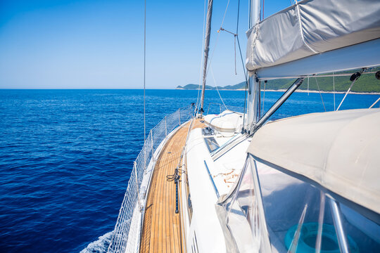 View from the deck of a modern sailing yacht cruising along the Adriatic Sea coast in Croatia. Luxury sailing travel and freedom at sea concept.