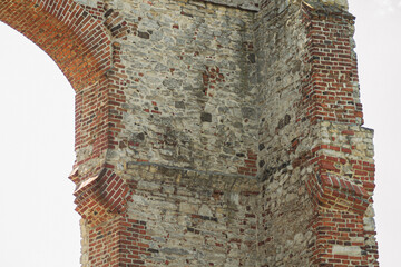 Weathered Polish castle ruin with tall stone and brick arch © Artem