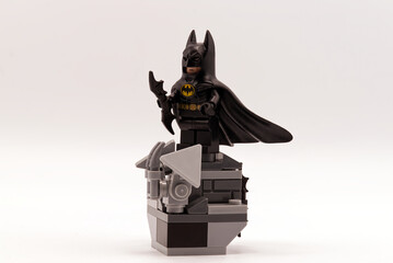 Fototapeta premium Bologna - Italy - August 9, 2026: Batman lego standing on a brick pedestal isolated on a white background.