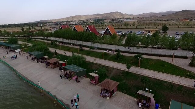 High quality aerial footage captures lakeside recreational area with flyboard activity and people enjoying the park facilities.